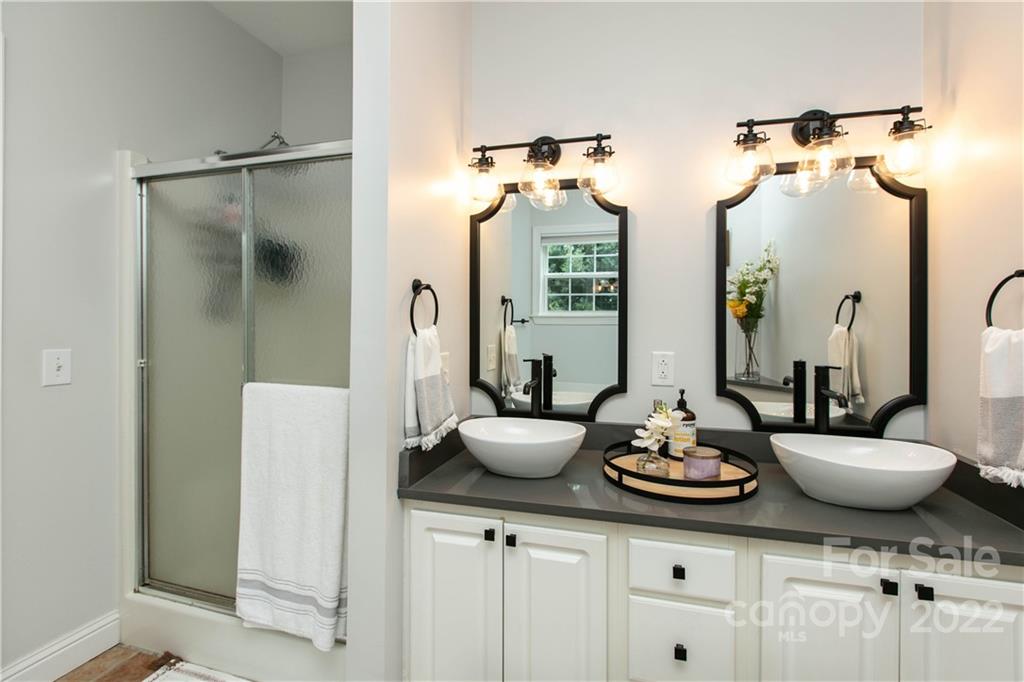 991 Golf Course Road Tryon, NC 28782 - Photo 41 of 43 a bathroom with a granite countertop sink and a mirror