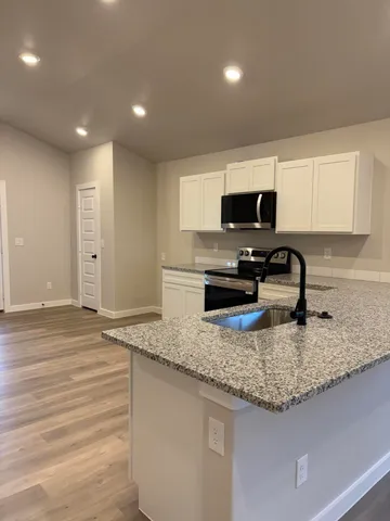 a bathroom with a granite countertop sink a mirror and vanity