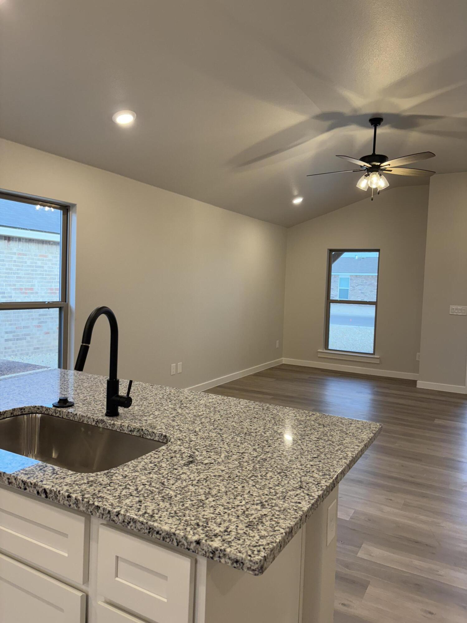 7222 35th Street Lubbock, TX 79407 - Photo 4 of 11 a bathroom with a granite countertop sink a mirror and vanity