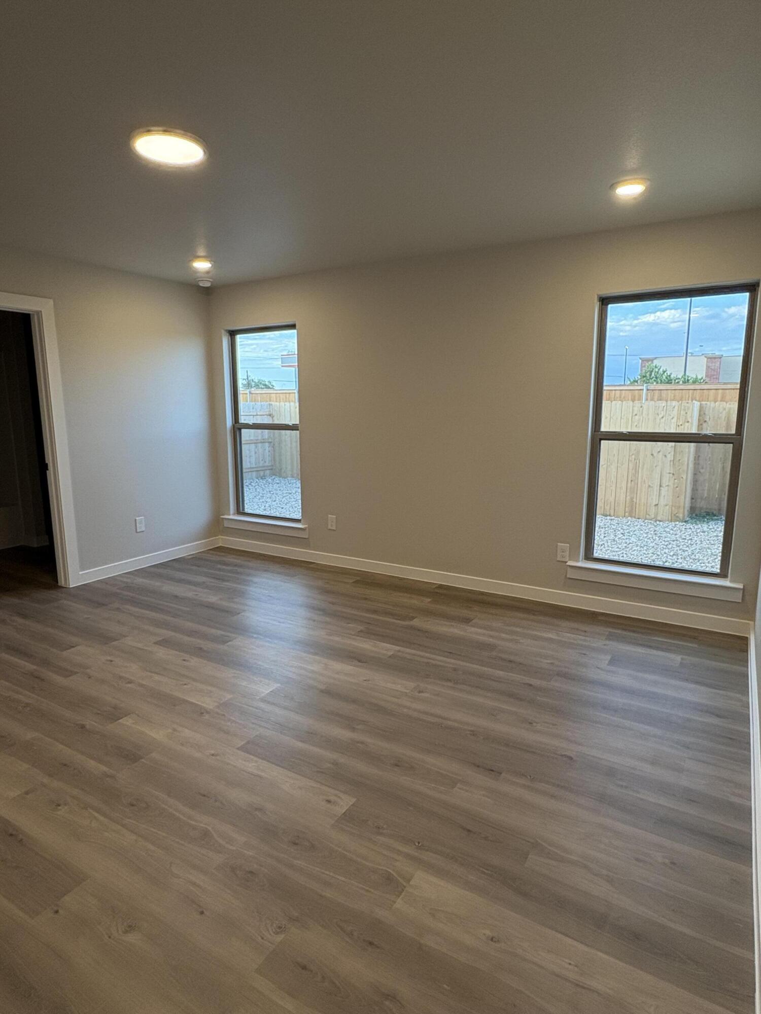 7222 35th Street Lubbock, TX 79407 - Photo 9 of 11 an empty room with wooden floor and windows
