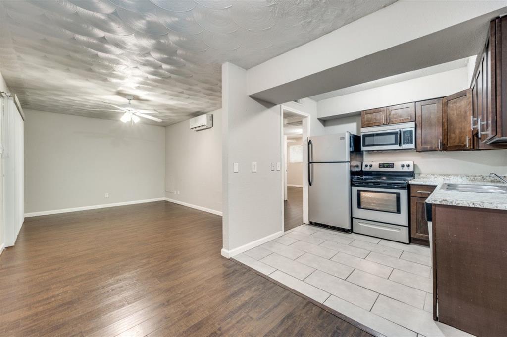 811 Skillman Street, Unit 104 Dallas, TX 75214 - Photo 1 of 1 a kitchen with granite countertop a refrigerator and a stove top oven