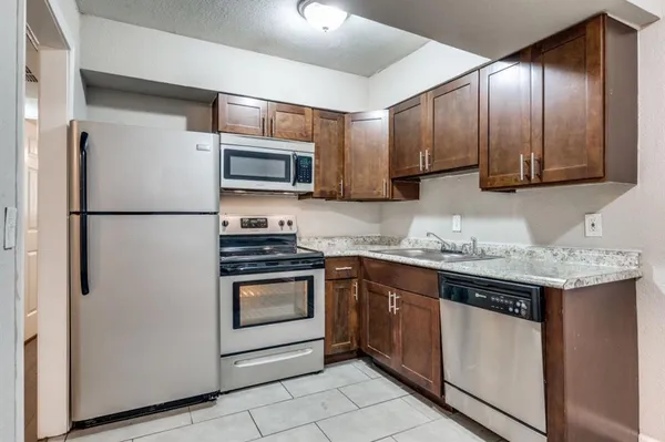 a kitchen with granite countertop stainless steel appliances and wooden cabinets