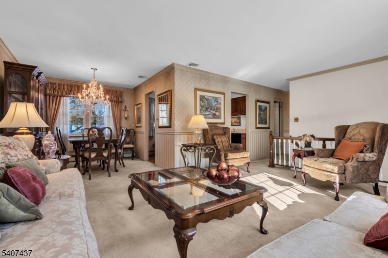9 Corsica Road Hopatcong, NJ 07843 - Photo 13 of 33 a living room with furniture a chandelier and a flat screen tv
