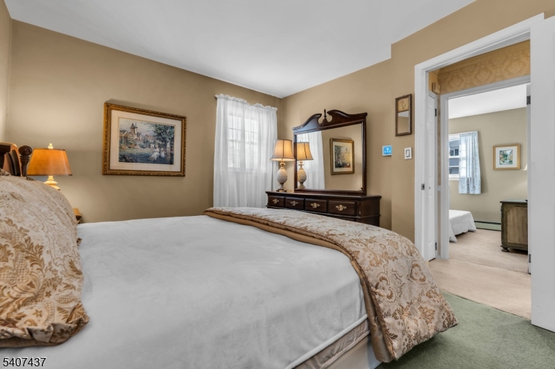 9 Corsica Road Hopatcong, NJ 07843 - Photo 22 of 33 a bedroom with a large bed and a chandelier