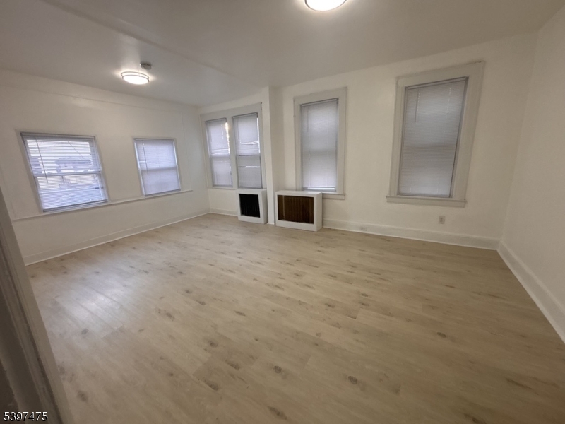 237 Fulton Street Paterson, NJ 07501 - Photo 3 of 11 an empty room with windows and fireplace