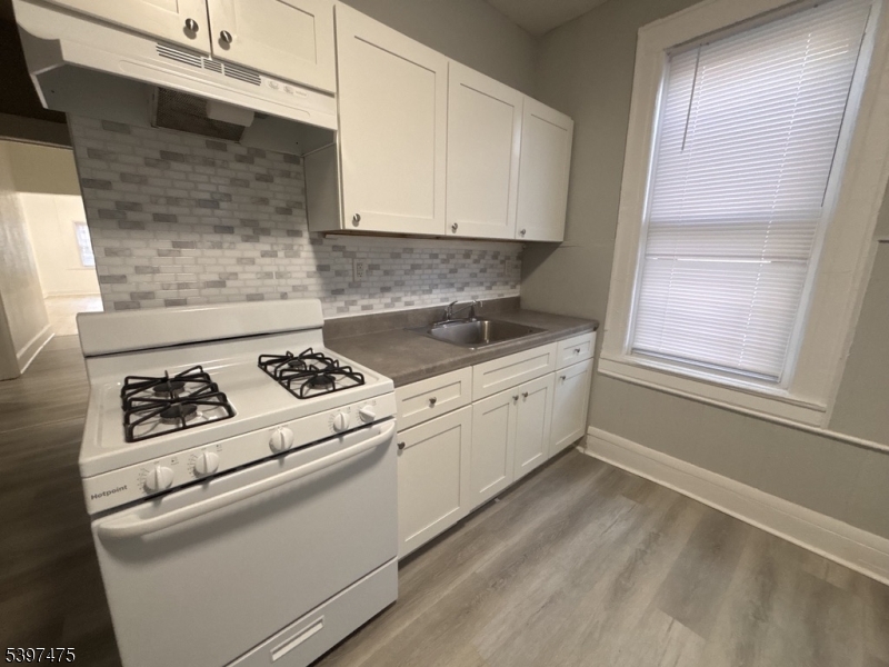237 Fulton Street Paterson, NJ 07501 - Photo 5 of 11 a white kitchen with a stove top oven