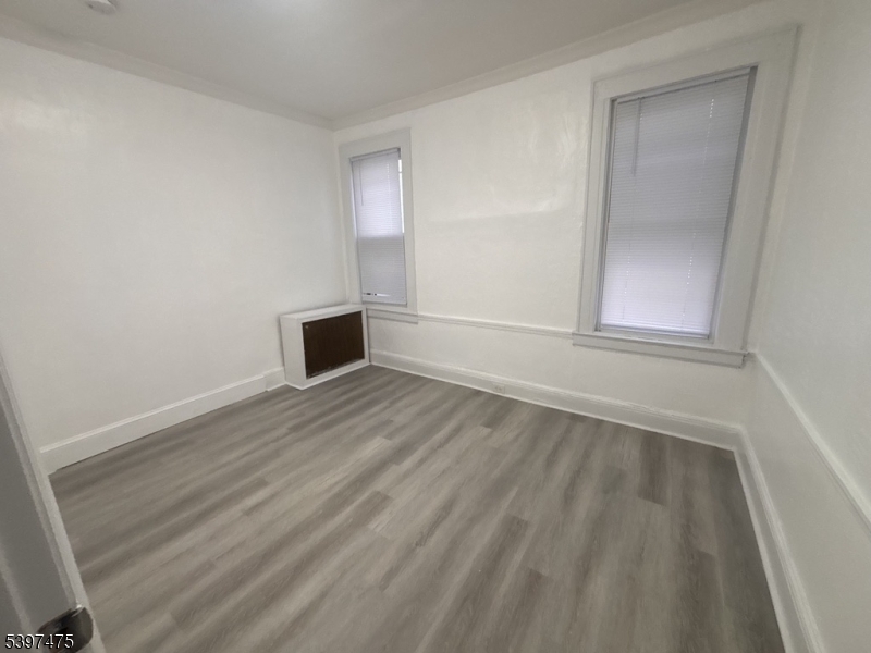 237 Fulton Street Paterson, NJ 07501 - Photo 10 of 11 an empty room with wooden floor and windows