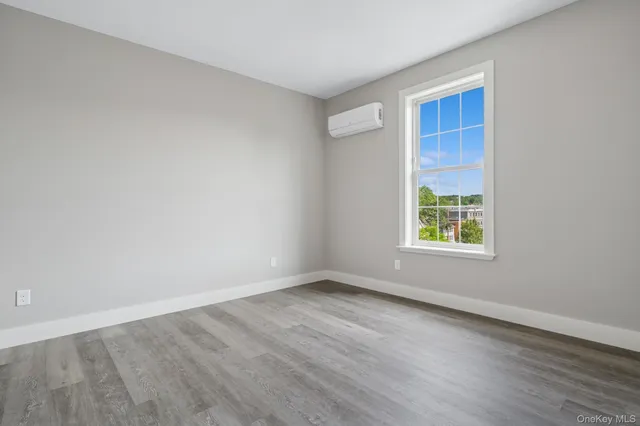 a kitchen with stainless steel appliances granite countertop a refrigerator a sink a stove a microwave and white cabinets with wooden floor