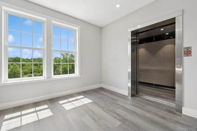 a view of empty room with wooden floor and window