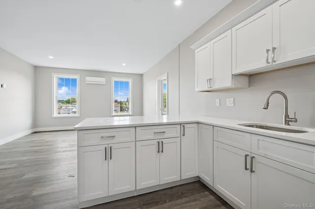 a kitchen with white cabinets white sink and dishwasher