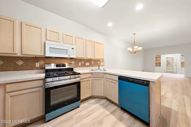 a kitchen with granite countertop stainless steel appliances a stove a sink and a microwave