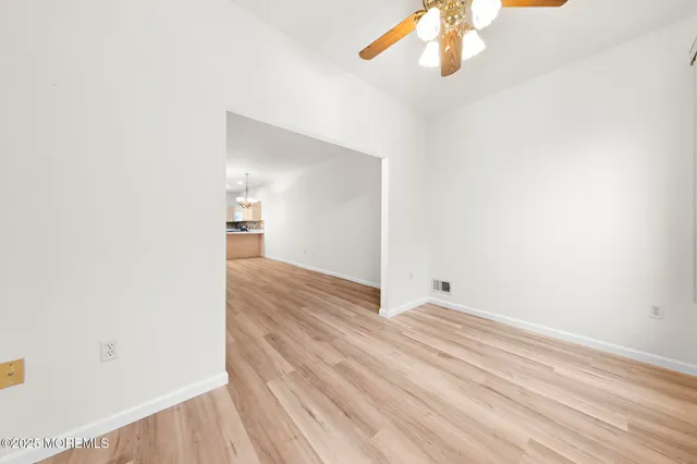 a view of a room with wooden floor and ceiling fan