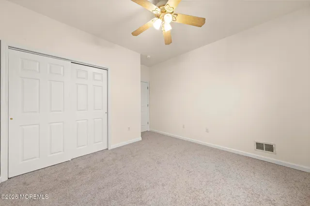 an empty room with a chandelier fan