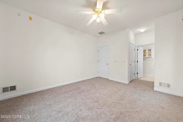 an empty room with a ceiling fan and a fan