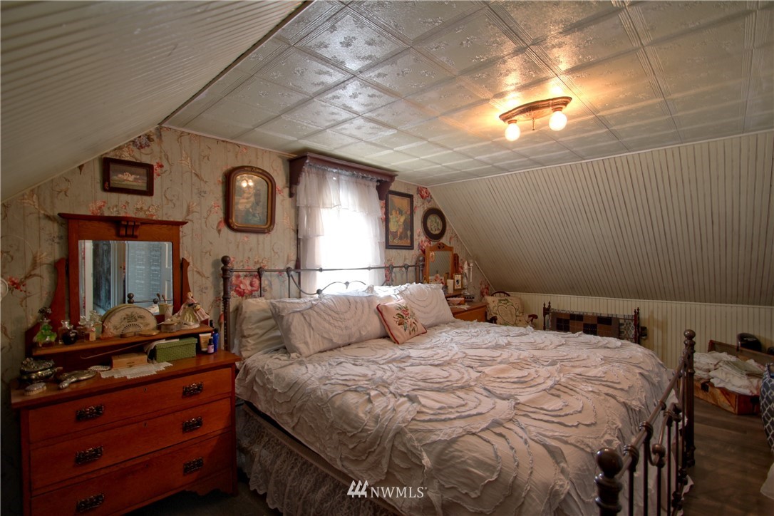 30217 Oso Loop Road Arlington, WA 98223 - Photo 27 of 34 a bedroom with a bed a mirror and a large window