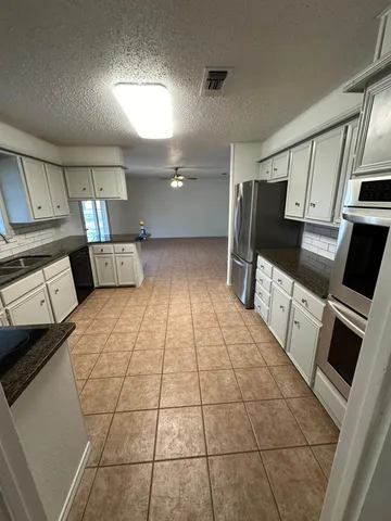 a kitchen with stainless steel appliances a refrigerator sink and microwave