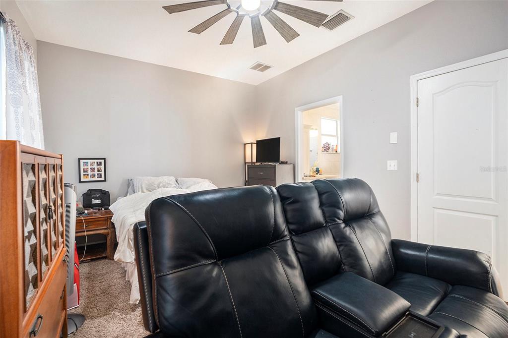 11808 Colony Lakes Boulevard New Port Richey, FL 34654 - Photo 12 of 25 a hotel room with a bed and a ceiling fan