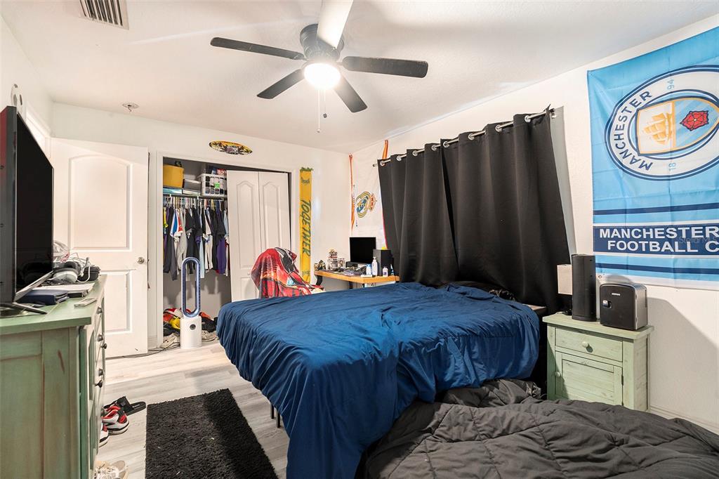 11808 Colony Lakes Boulevard New Port Richey, FL 34654 - Photo 14 of 25 a bedroom with a bed and a chandelier