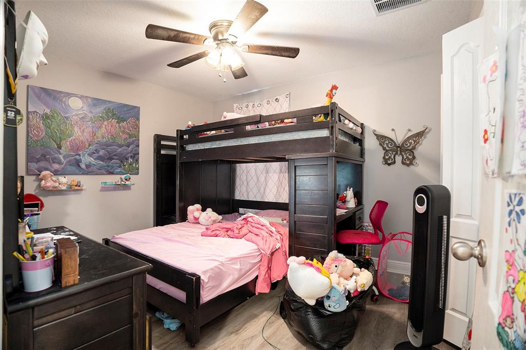 11808 Colony Lakes Boulevard New Port Richey, FL 34654 - Photo 19 of 25 a bedroom with a bed and a chandelier