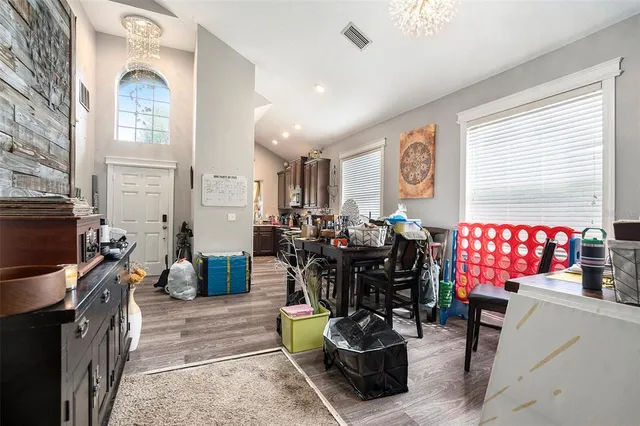 a living room with furniture a dining table and chairs with the kitchen view