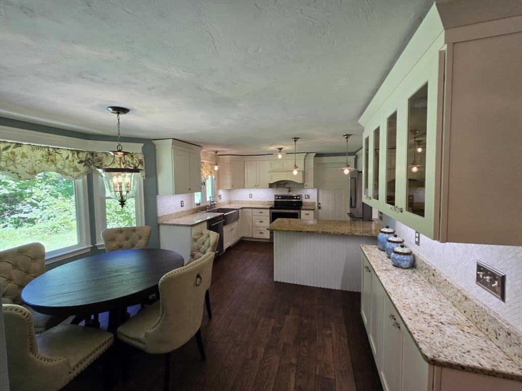 8 Caleb Road Shirley, MA 01464 - Photo 4 of 42 a kitchen with a table chairs stove and wooden floor