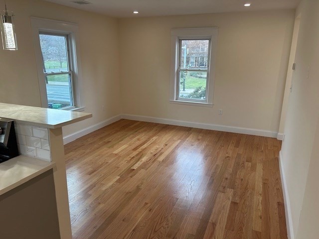 1599 Washington Street, Unit 2 Newton, MA 02465 - Photo 12 of 34 an empty room with wooden floor and windows