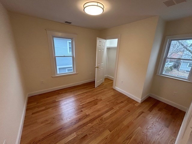 1599 Washington Street, Unit 2 Newton, MA 02465 - Photo 18 of 34 an empty room with wooden floor and windows