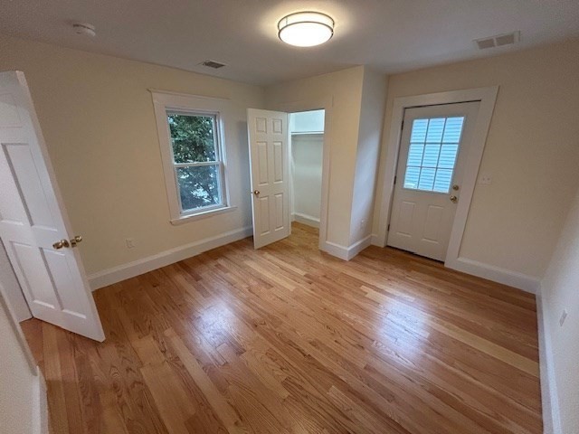 1599 Washington Street, Unit 2 Newton, MA 02465 - Photo 23 of 34 an empty room with wooden floor and windows