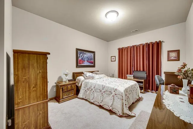 a bedroom with a large bed and a chandelier