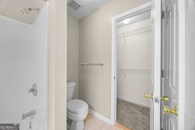 a bathroom with a granite countertop toilet and a sink