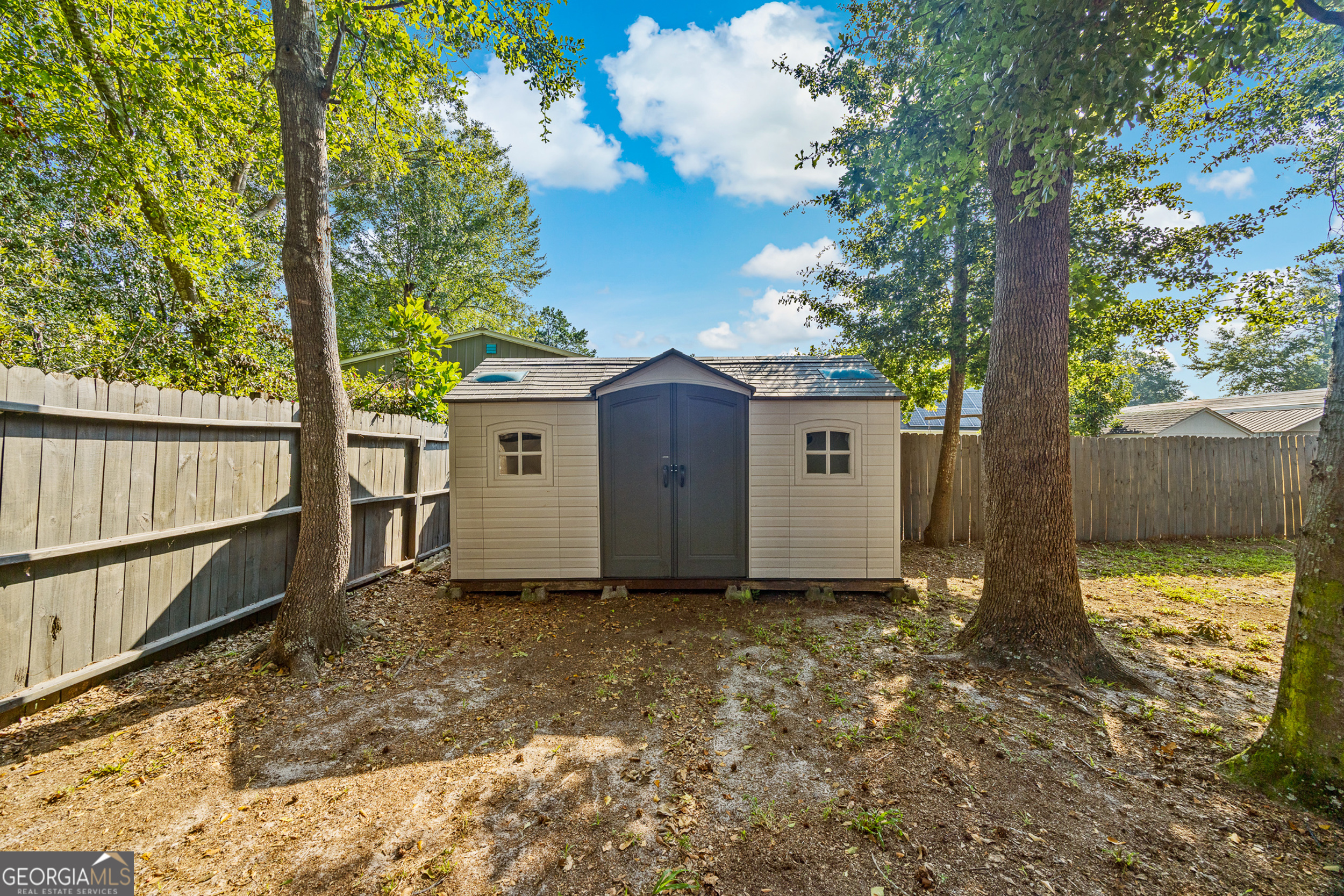 108 Crossing Circle Rincon, GA 31326 - Photo 23 of 26 a view of a small house in the backyard with large tree and wooden fence