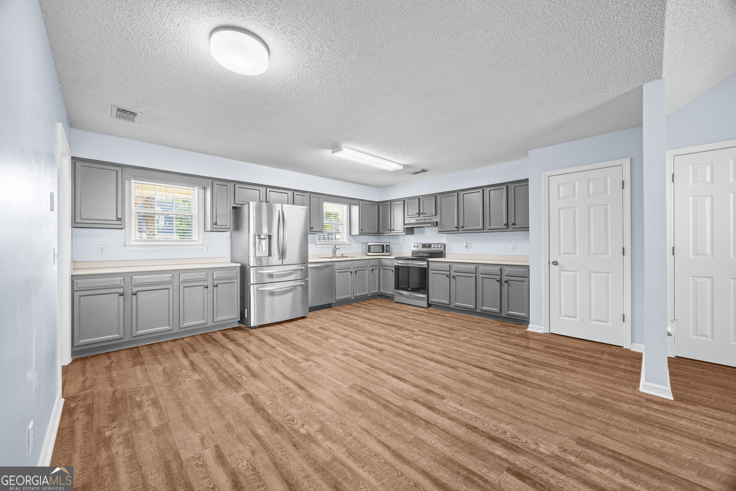 108 Crossing Circle Rincon, GA 31326 - Photo 6 of 26 a large white kitchen with cabinets and wooden floor