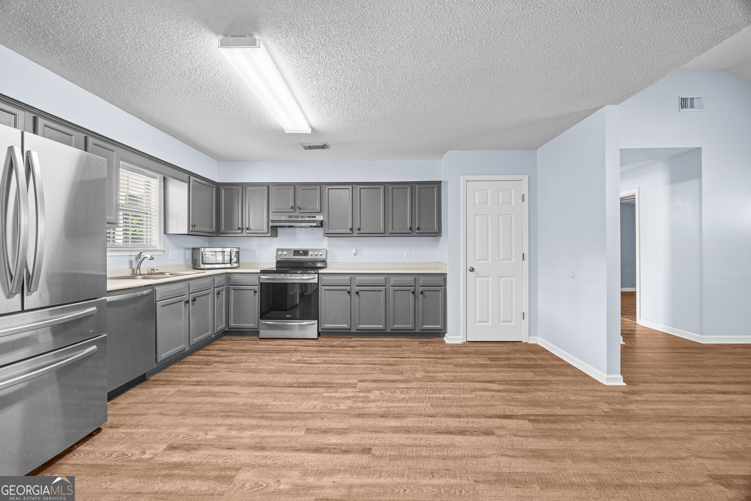 108 Crossing Circle Rincon, GA 31326 - Photo 7 of 26 a kitchen with a white cabinets and wooden floor