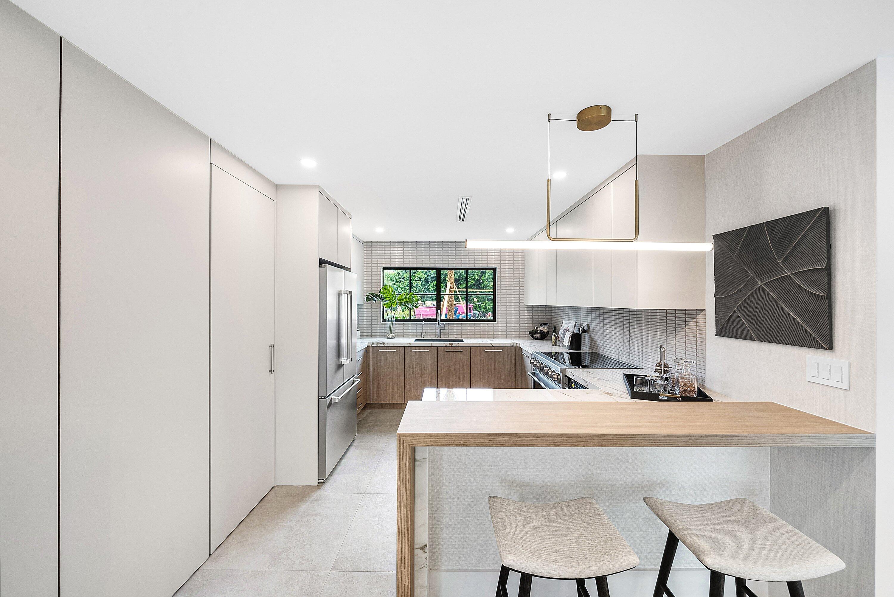 478 Northwest 13th Street Boca Raton, FL 33432 - Photo 11 of 38 a kitchen with a table chairs refrigerator and microwave
