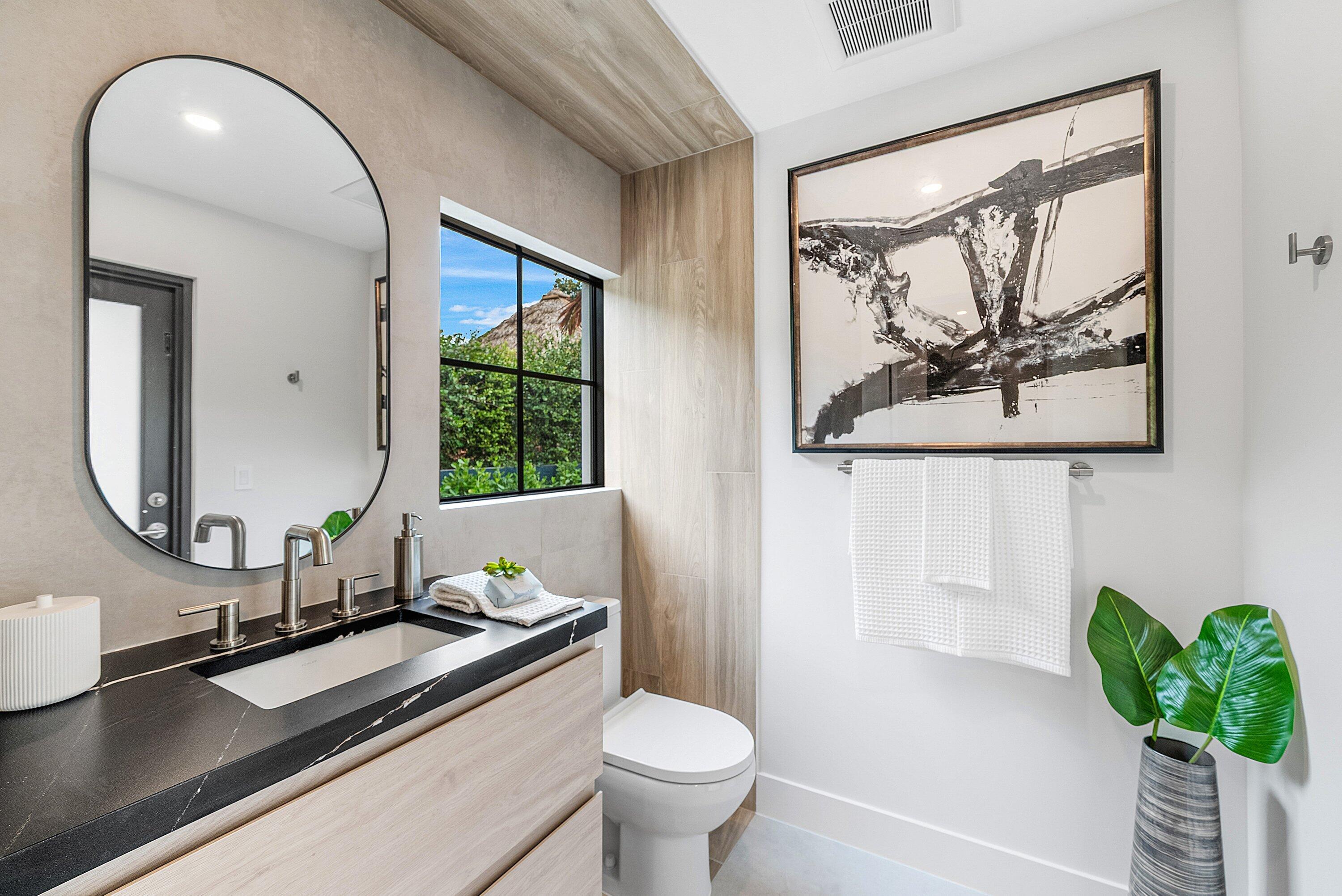 478 Northwest 13th Street Boca Raton, FL 33432 - Photo 34 of 38 a bathroom with a toilet sink and mirror