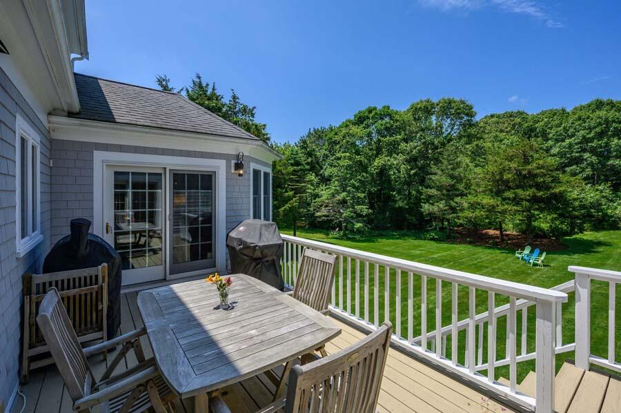 80 Old Kings Road Cotuit, MA 02635 - Photo 27 of 47 a view of a deck with furniture and a yard
