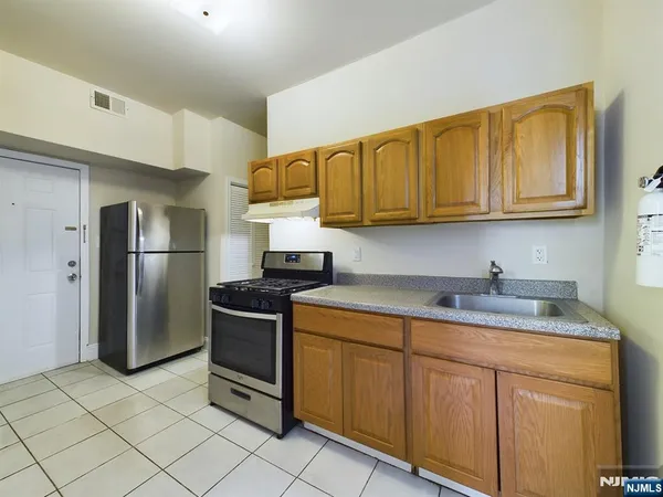 a kitchen with stainless steel appliances granite countertop a stove a refrigerator and a sink