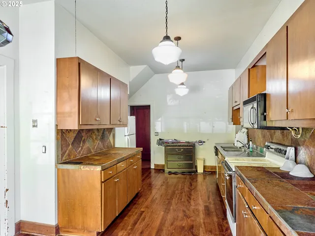 a kitchen with stainless steel appliances granite countertop a sink a stove and a refrigerator