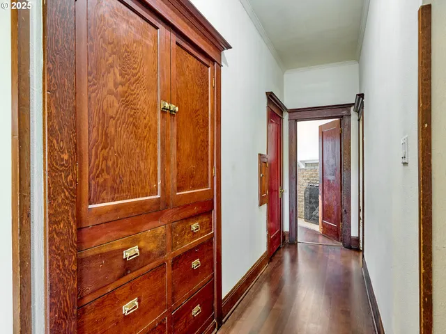 a view of a hallway with wooden floor and a window