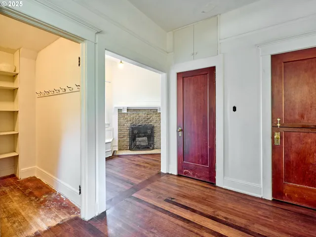 a view of a hallway with wooden floor and a fireplace