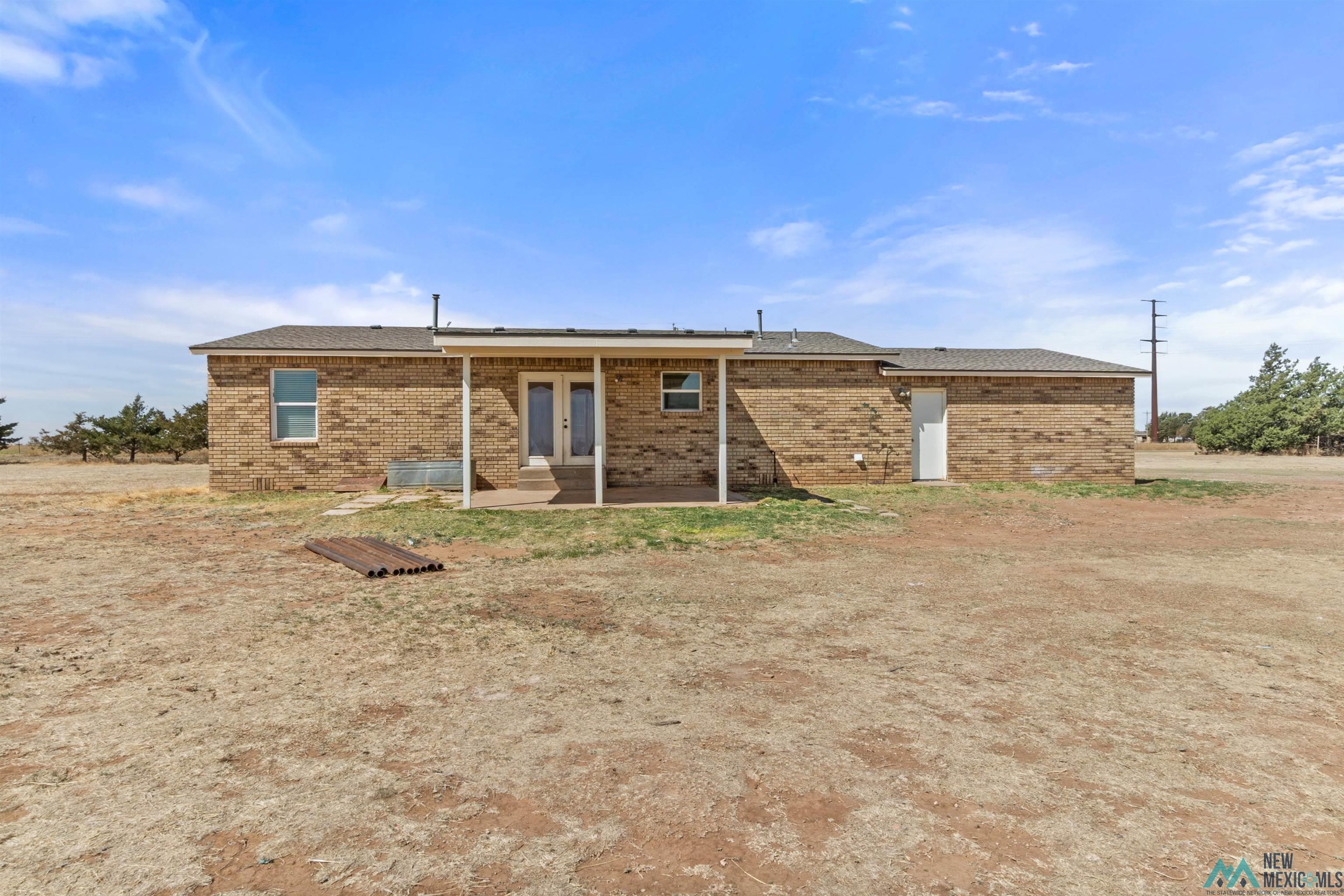 1691 County Rd K Clovis, NM 88101 - Photo 20 of 22 Rear view of property with brick siding and french doors