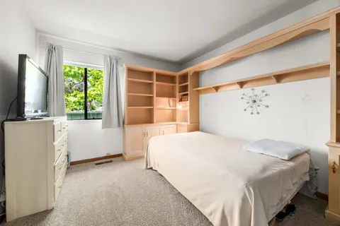a bedroom with a large bed and a flat tv screen