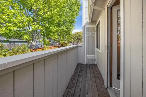a view of a balcony with wooden floor and fence