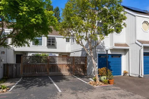 a front view of a house with a tree