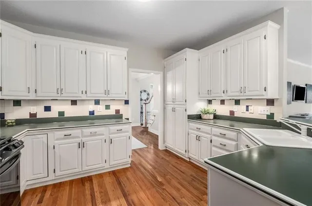 a kitchen with granite countertop white cabinets and white appliances