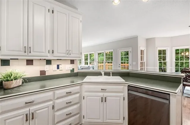 a kitchen with granite countertop white cabinets and white stainless steel appliances