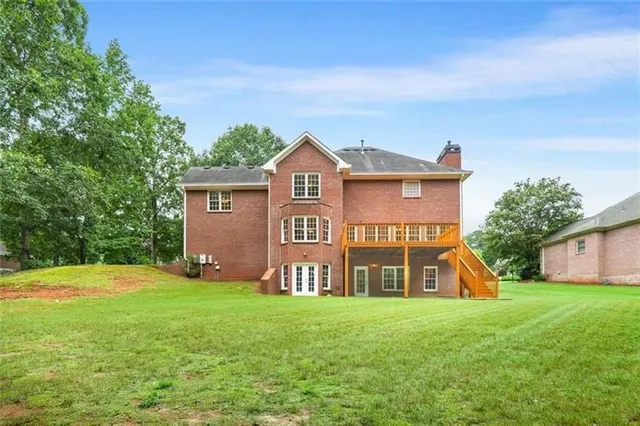 a view of a house with a big yard plants and large trees