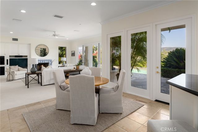 a dining room with wooden floor a chandelier a wooden table and chairs
