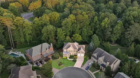 a view of swimming pool with seating area and trees in the background