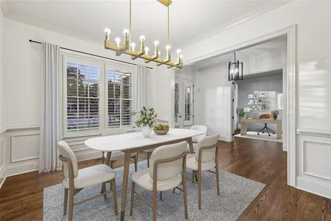 a dining room with furniture potted plants and wooden floor